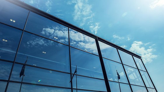 Reflection of three flags on a glass building of Volvo Group